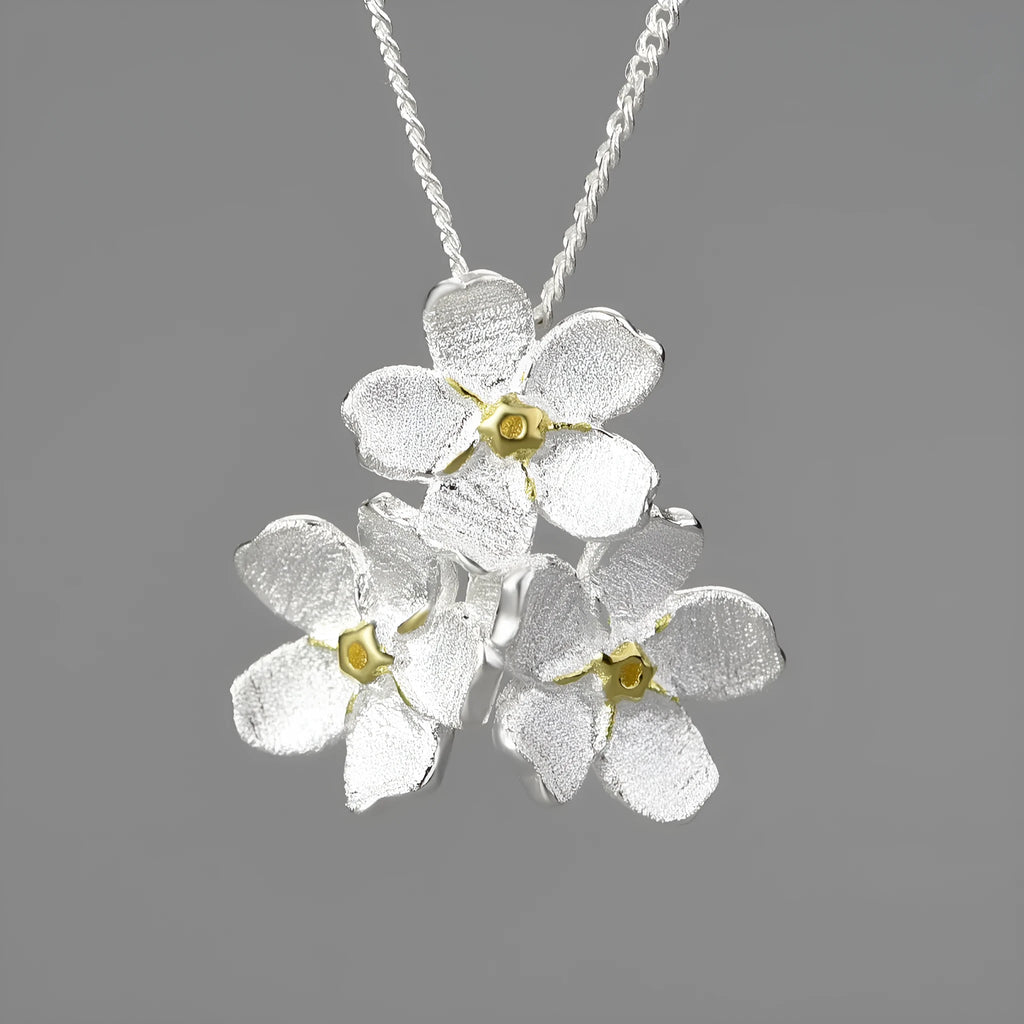 Sterling silver forget-me-not floral pendant in pastoral style, shown in gold and silver electroplated finishes.