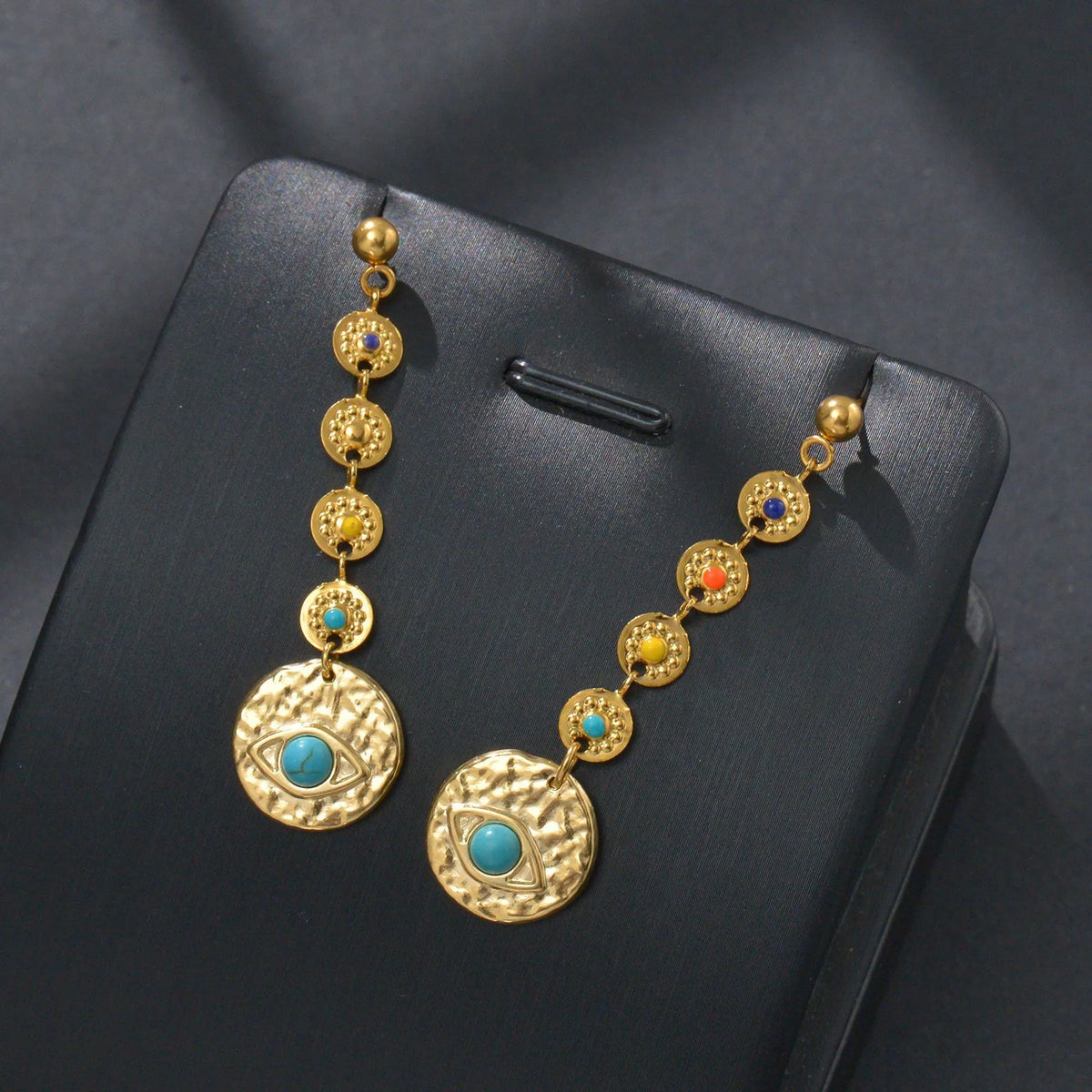 Geometric stainless steel earrings showing eight awn star, eye pattern, and shell sun designs