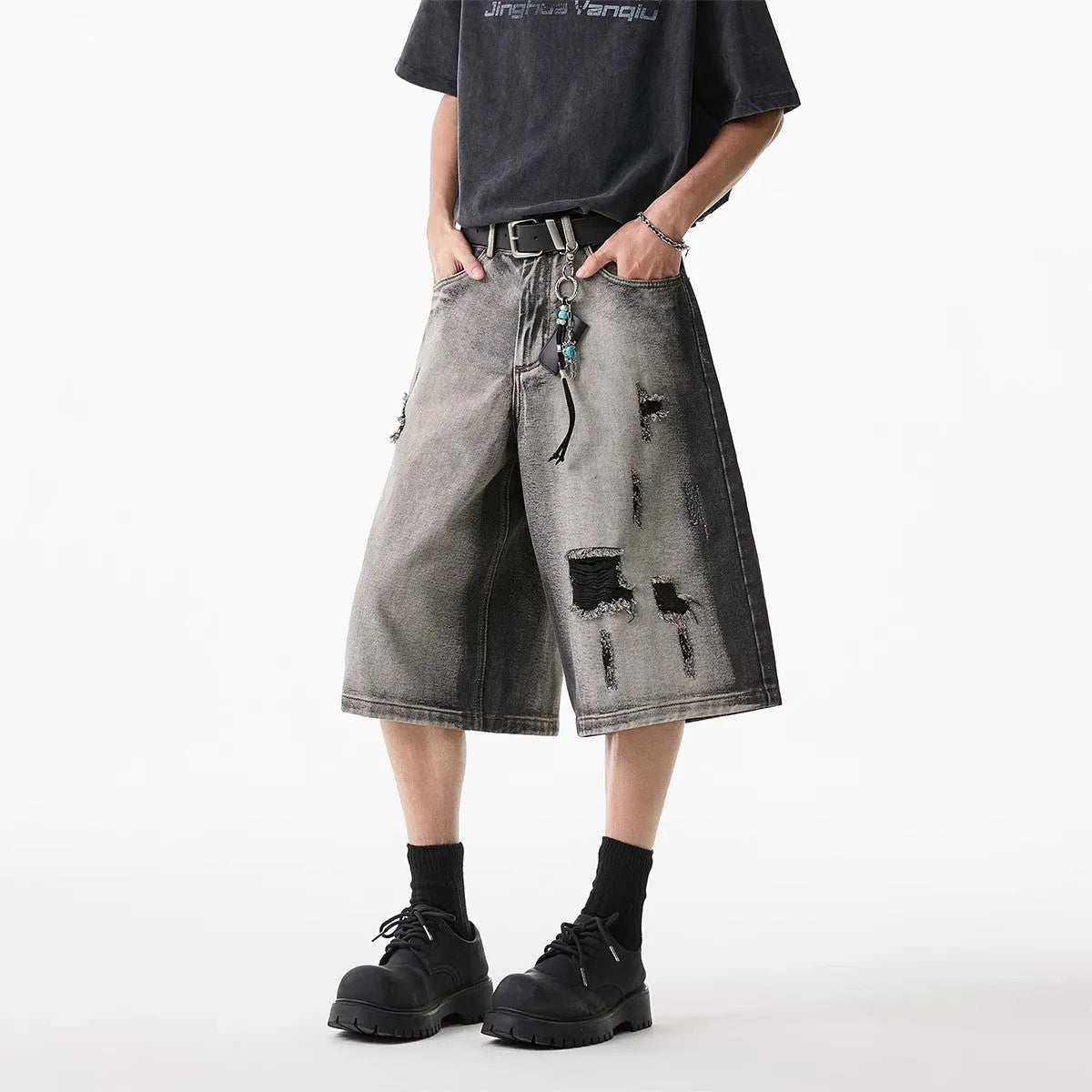 Women's loose-fit washed grey denim shorts with distressed hole details, cropped length.