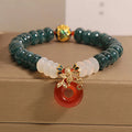 Blue jade and red agate bead bracelet with a crystal peace buckle closure.