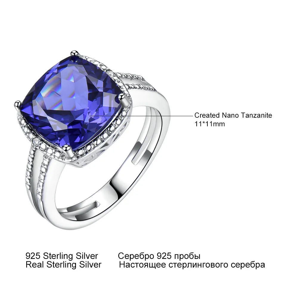 Blue tanzanite gemstone set in a sterling silver women's ring on a grey background.