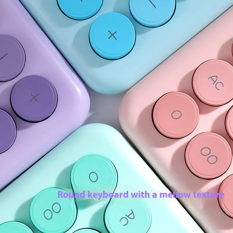 A gradient colour desktop calculator in violet, pink, blue, or green on a desk.