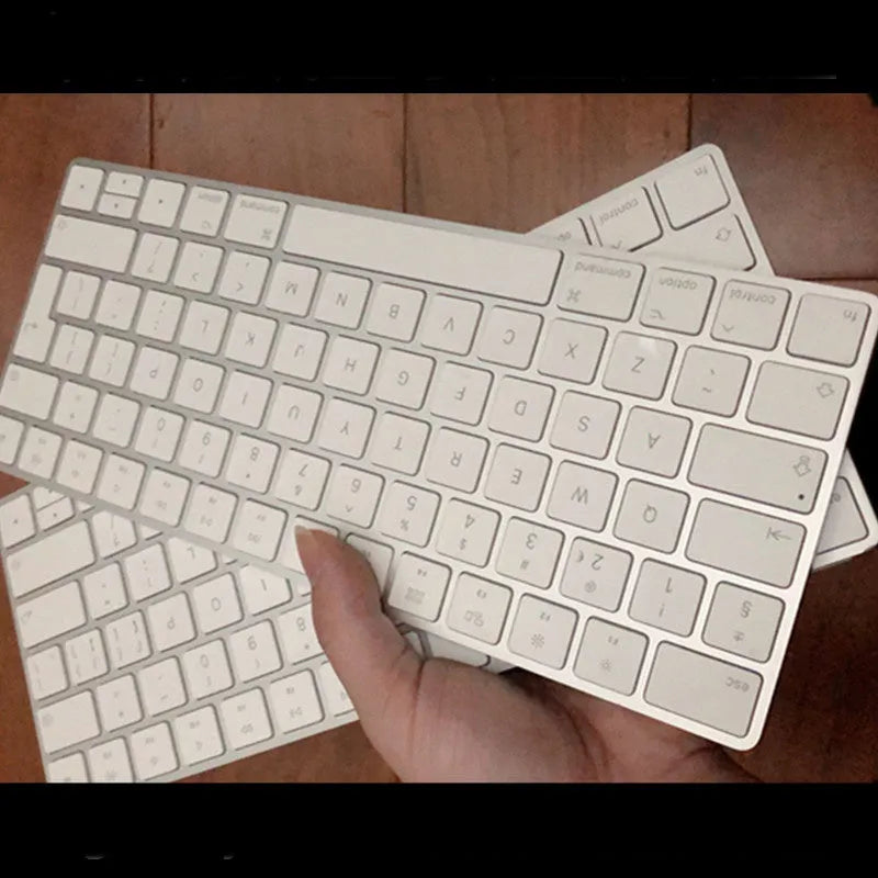 White genuine Apple Bluetooth wireless keyboard with ultra-thin metal casing on a desk.