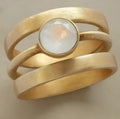 Gold-plated geometric ring with hollow micro-inlaid white chalcedony on titanium steel band