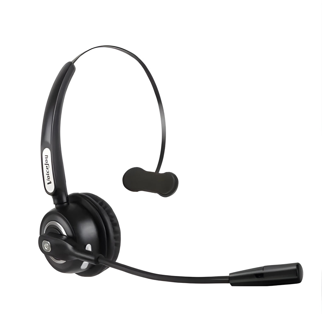 A black Bluetooth over-ear headset with a bendable microphone boom, shown on a desk next to a USB charging cable.