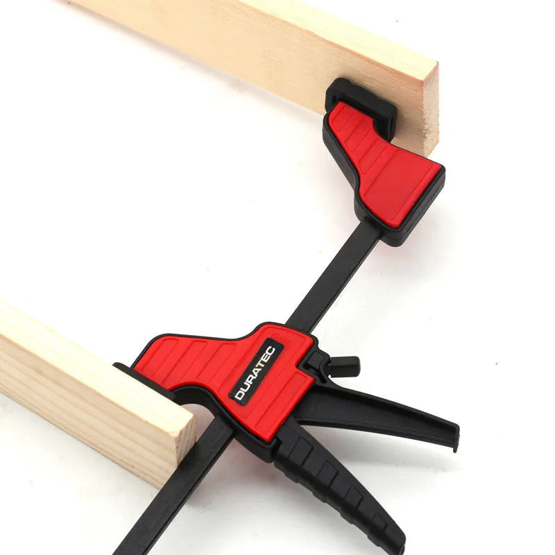 Plastic woodworking clamp with quick-release trigger and soft rubber contact surfaces
