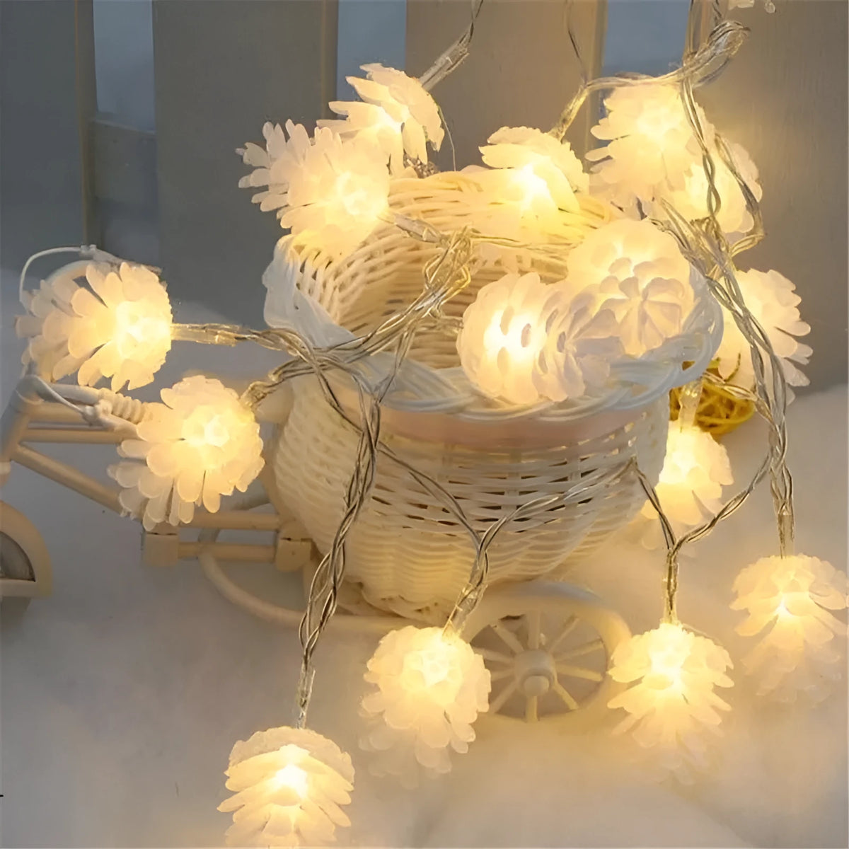 Warm white LED pine cone light string hanging decoratively, showing plastic shell details.
