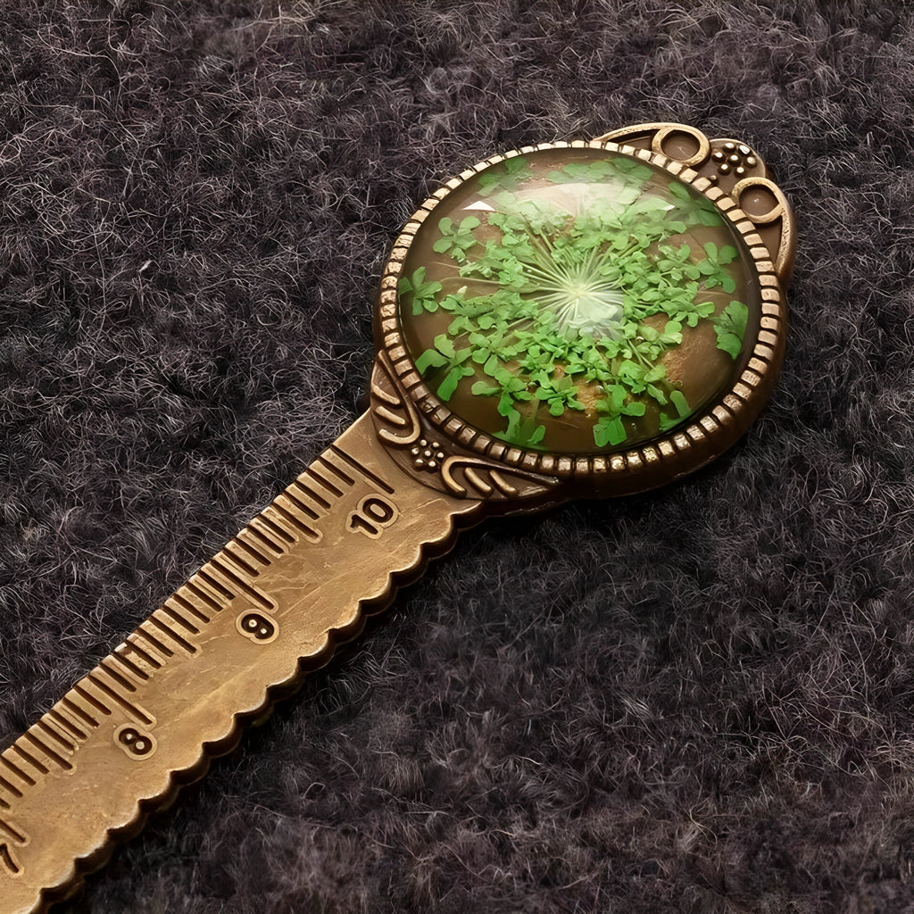 Handmade dried gypsophila, daffodil, and four-leaf clover bookmark on a book page.
