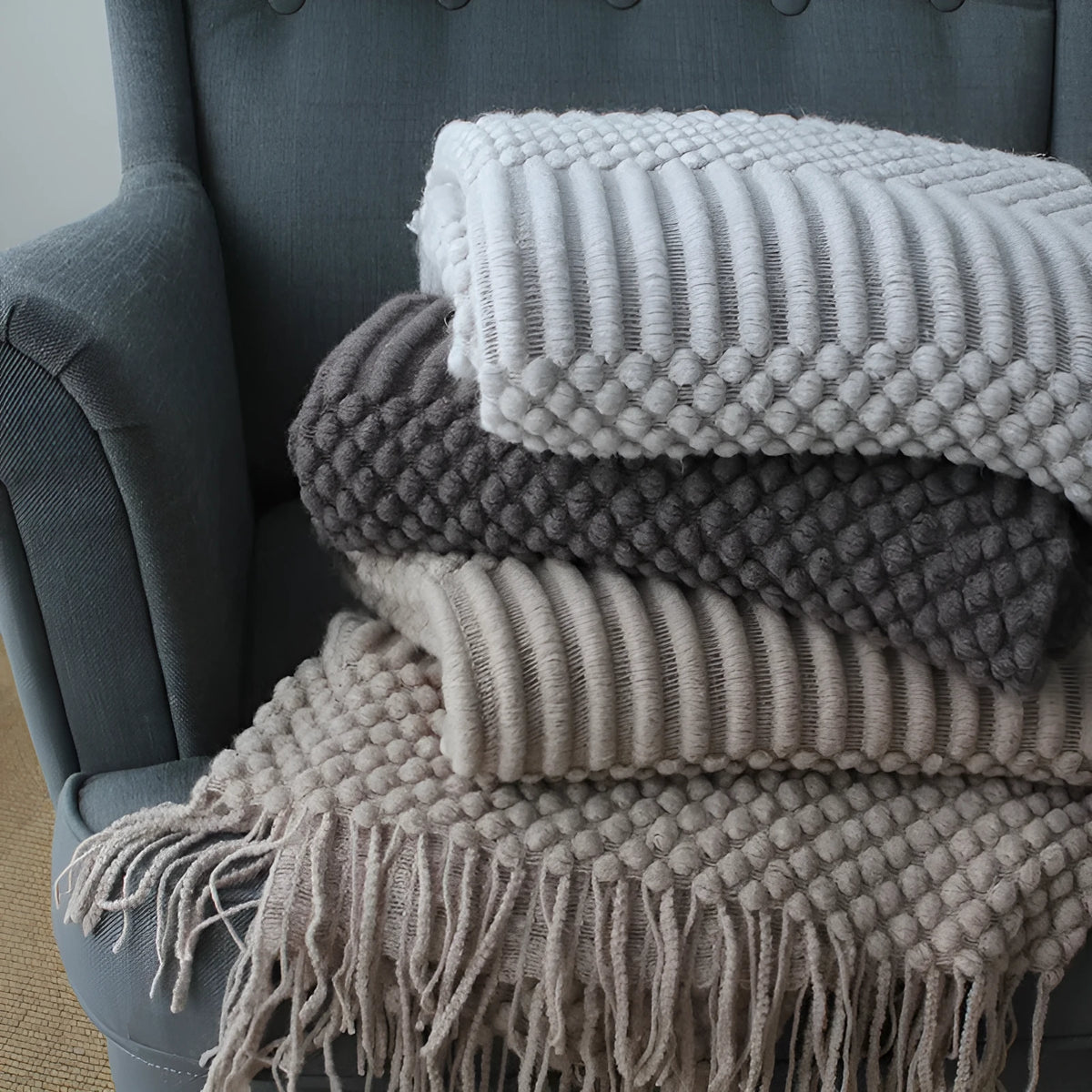 Small grey polyester nap blanket folded to show its size and texture.