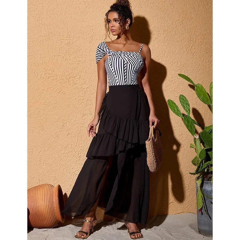 Women's striped one-piece swimsuit with black ruffle skirt detail for beach and pool wear
