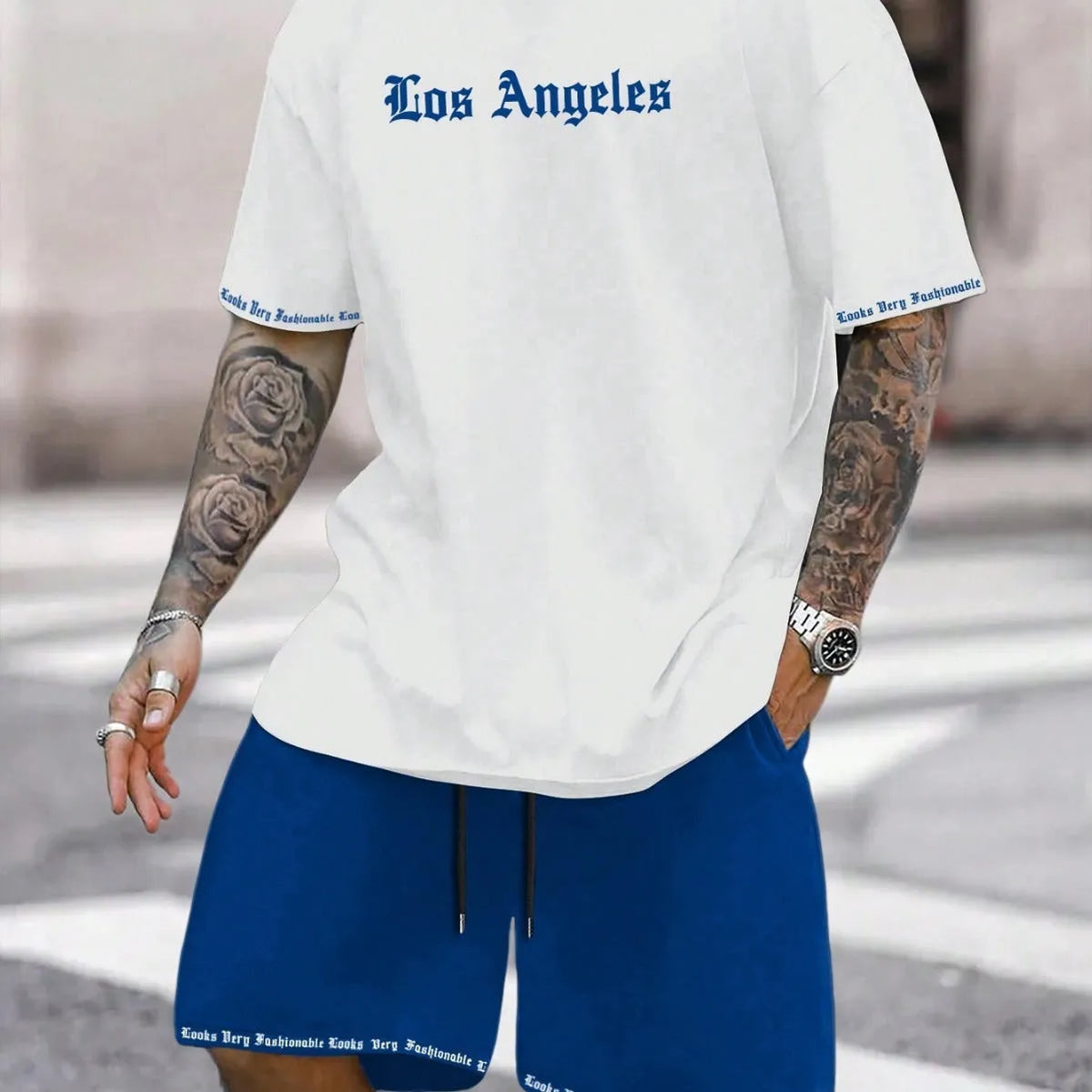 Mens blue sports style short sleeve top and shorts two-piece set on a plain background.