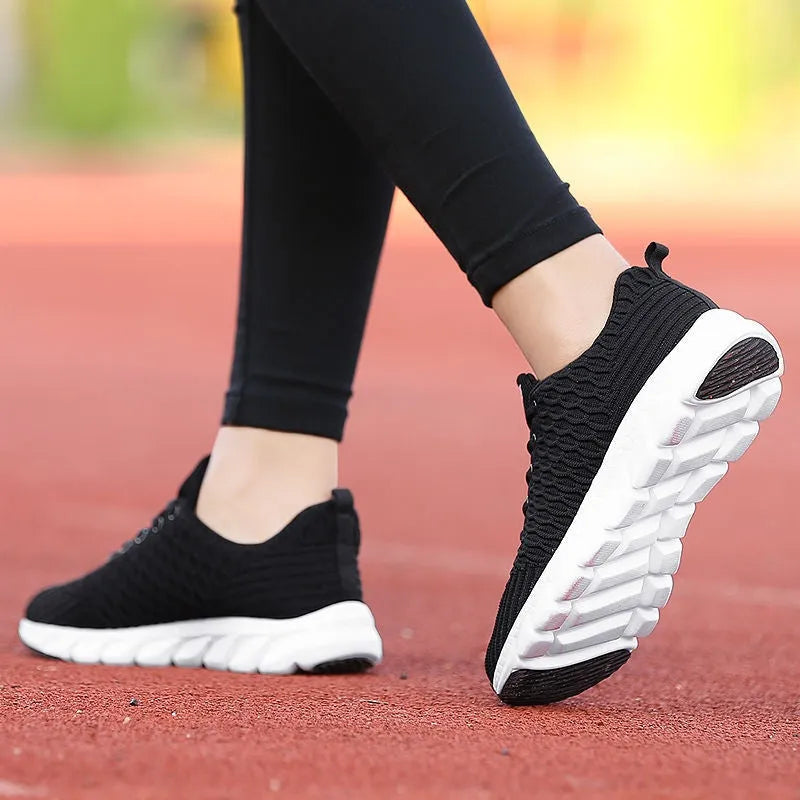 Women's running shoes in black, pink, or white with a fly weaving upper and rubber outsole.