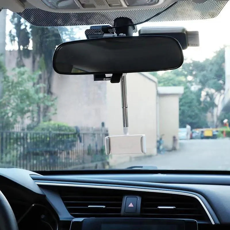 Black ABS plastic phone bracket mounted on car rearview mirror holding smartphone