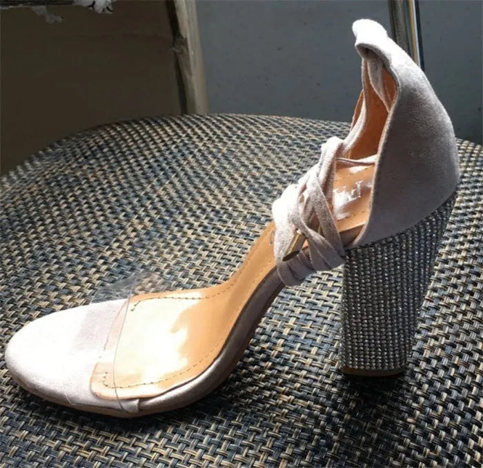 Black and gold plastic high heels with pointed toe design shown from side view