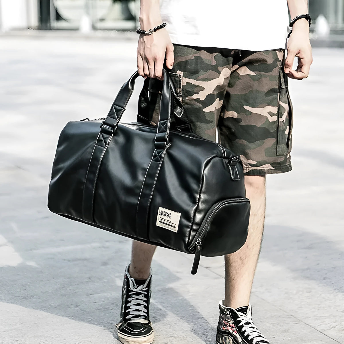 Large black waterproof PU leather sports training bag with multiple internal pockets, shown with a laptop compartment.