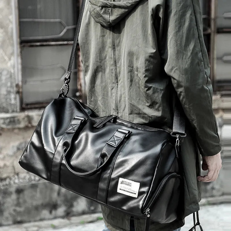 Large black waterproof PU leather sports training bag with multiple internal pockets, shown with a laptop compartment.