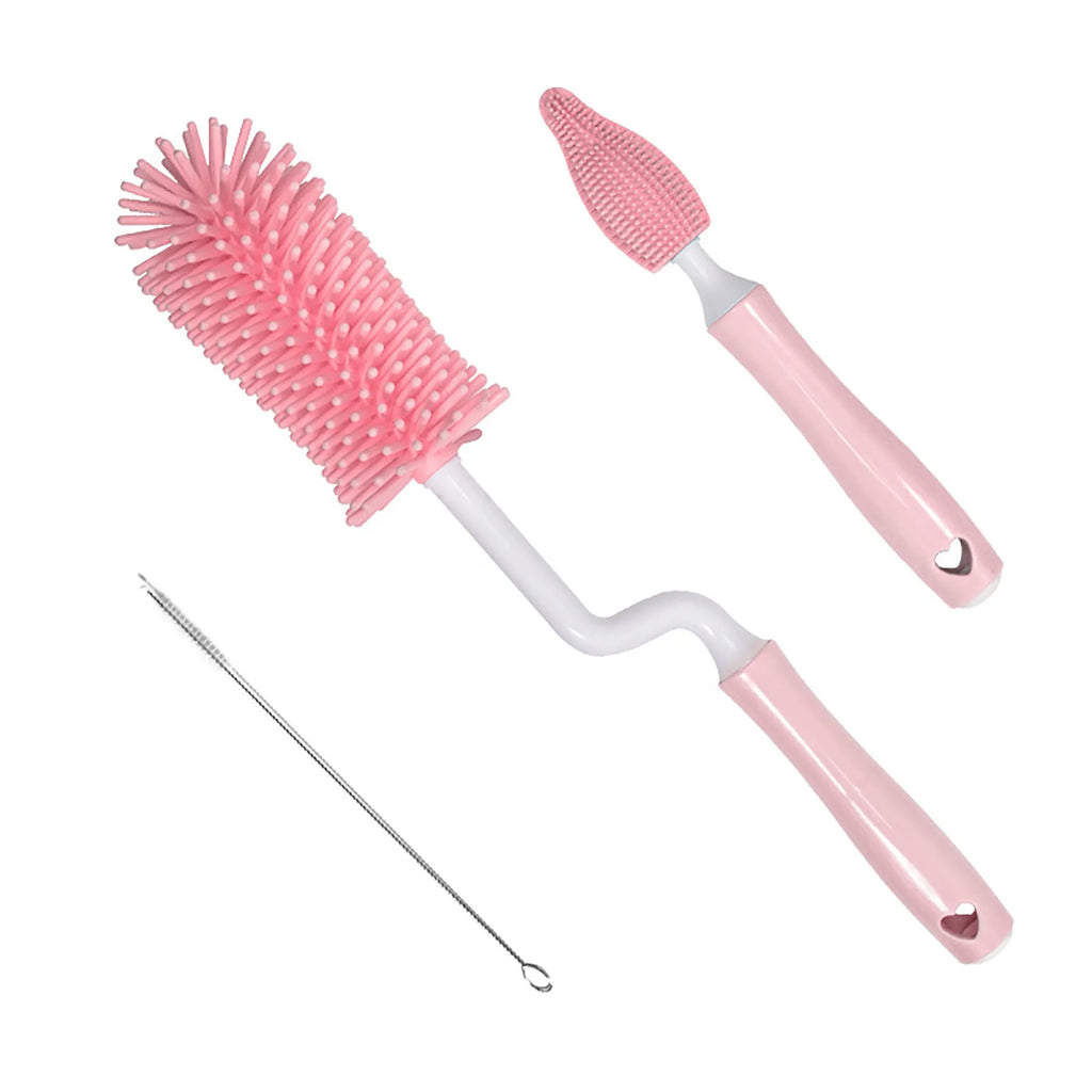 Three silicone baby bottle brushes on a counter, including a main brush and a narrow straw cleaning brush.