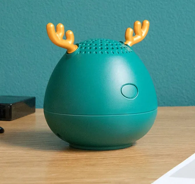 Small green portable Bluetooth speaker with USB cable on a white background.