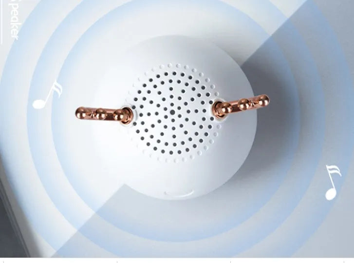 Small green portable Bluetooth speaker with USB cable on a white background.