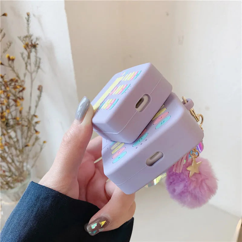 Purple silicone protective case for Apple AirPods with fur ball pendant, showing clamshell design