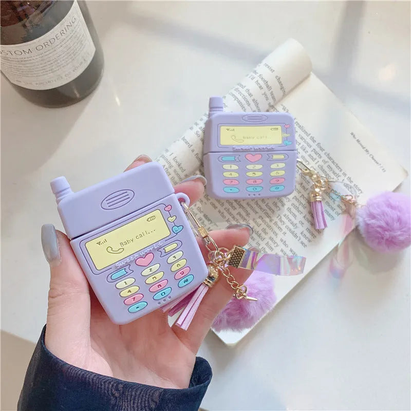 Purple silicone protective case for Apple AirPods with fur ball pendant, showing clamshell design