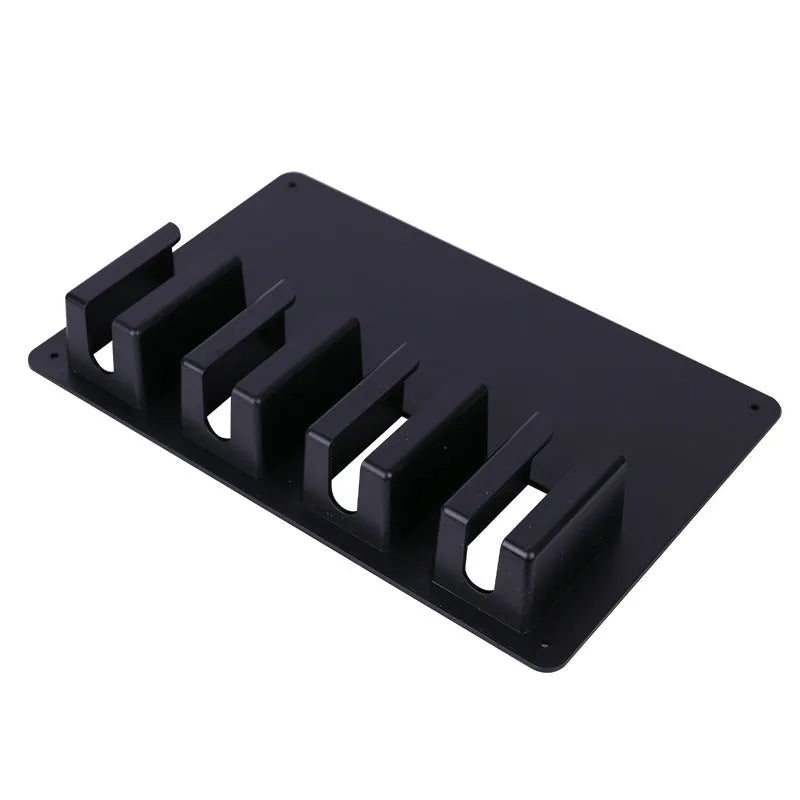 Black plastic wall-mounted rack holding four hair clippers with space for brushes and combs.