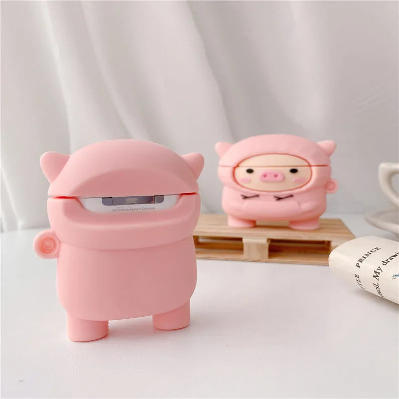 Pink silicone AirPods case with cartoon hoodie pig design, showing flip opening and attachment hook