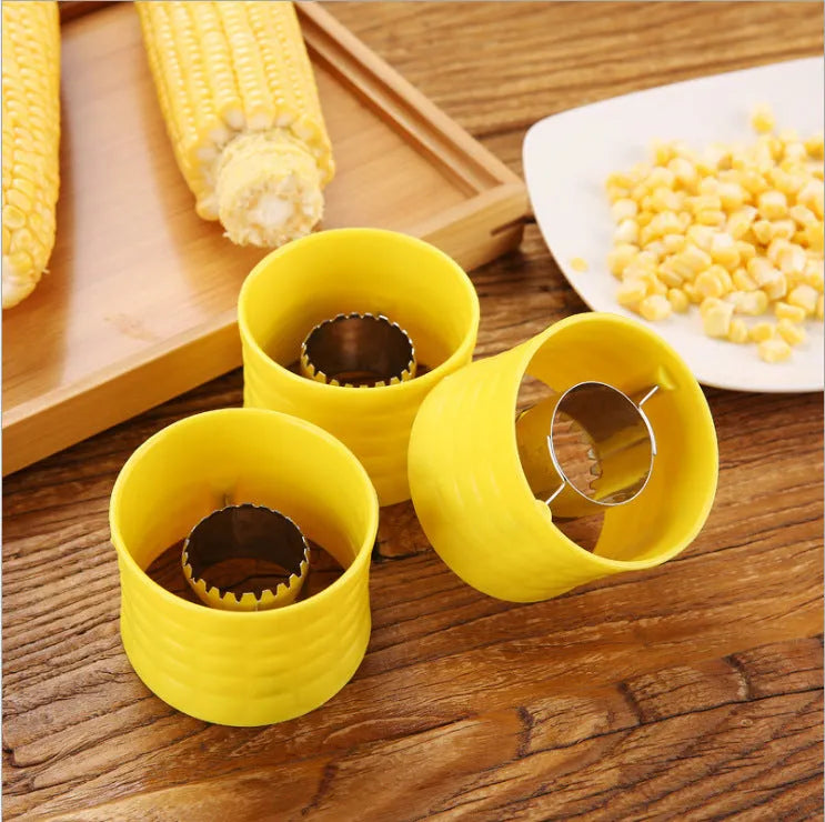 Yellow manual corn thresher kitchen gadget with corn-shaped design and stainless steel gear.