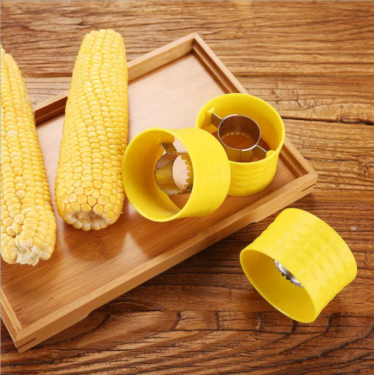 Yellow manual corn thresher kitchen gadget with corn-shaped design and stainless steel gear.