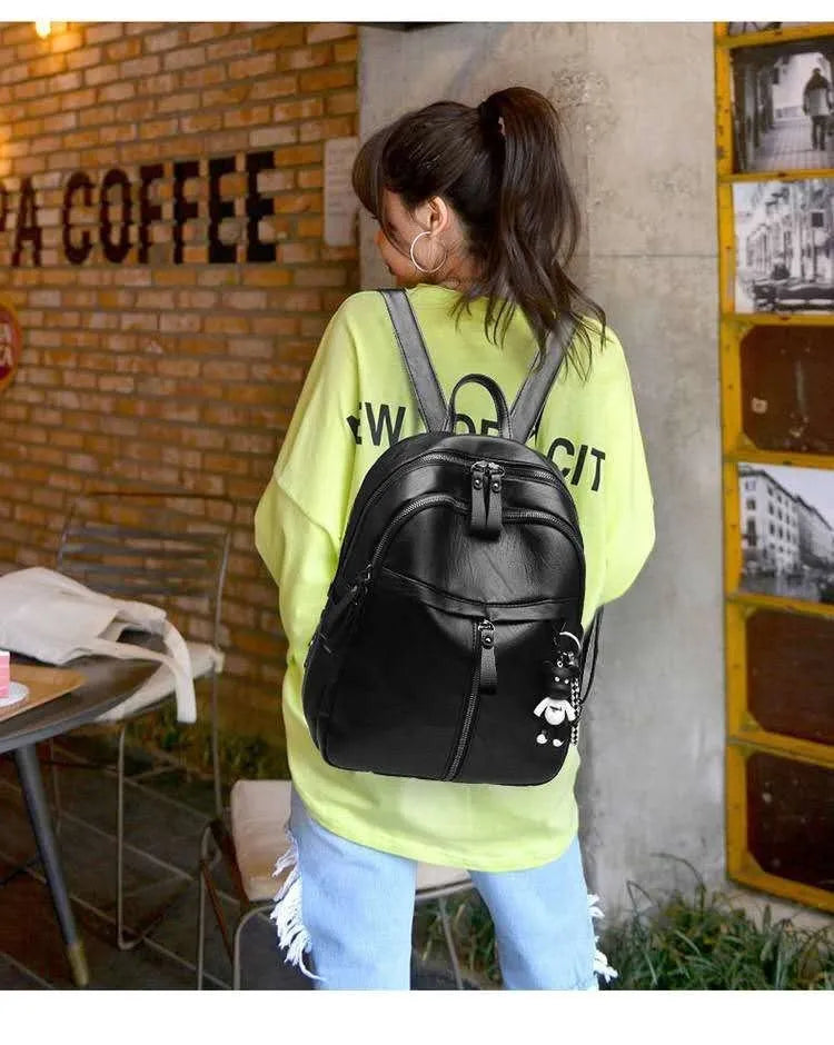 Black PU leather backpack with luggage straps showing ID compartment and zipper opening
