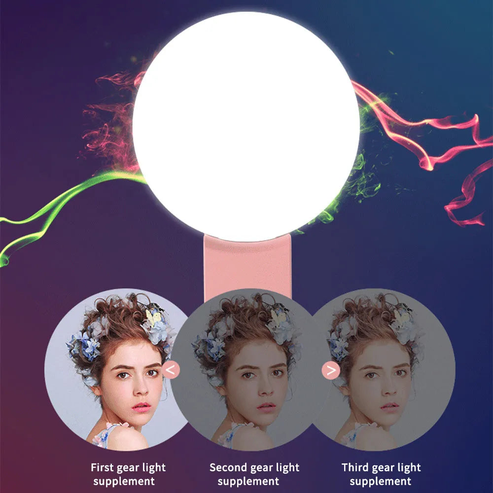 Small round white clip-on LED fill light attached to a mobile phone for selfie photography.