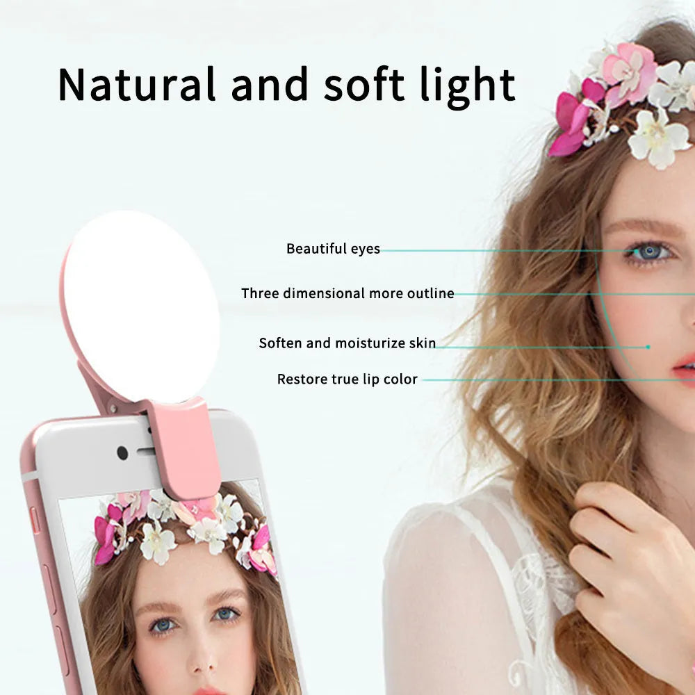 Small round white clip-on LED fill light attached to a mobile phone for selfie photography.