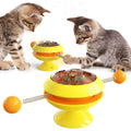 Rotating turntable cat toy with suction cup base and visible catnip balls in transparent top.