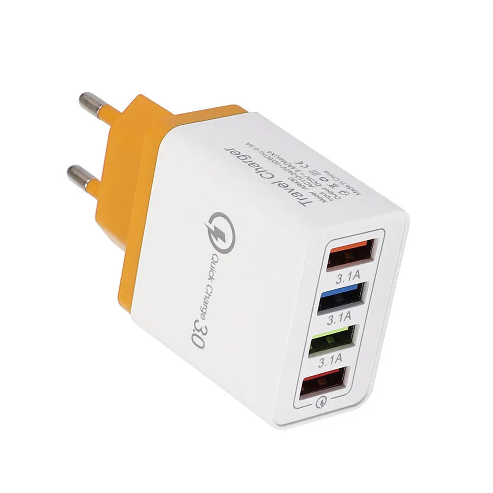 Compact 4-port USB mobile phone charger in multiple colours, shown plugged into a UK wall socket.