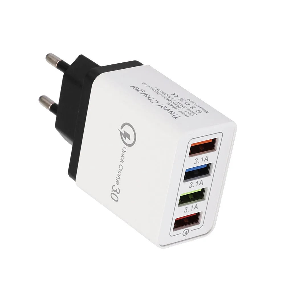 Compact 4-port USB mobile phone charger in multiple colours, shown plugged into a UK wall socket.