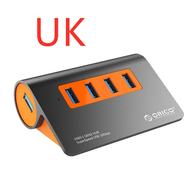 Dark grey aluminium USB hub with orange detailing showing four USB 3.1 ports and detachable cable