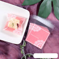 Pink self-adhesive plastic packaging bags in a pack, showing adhesive flap and size scale.