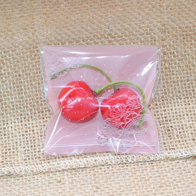Pink self-adhesive plastic packaging bags in a pack, showing adhesive flap and size scale.
