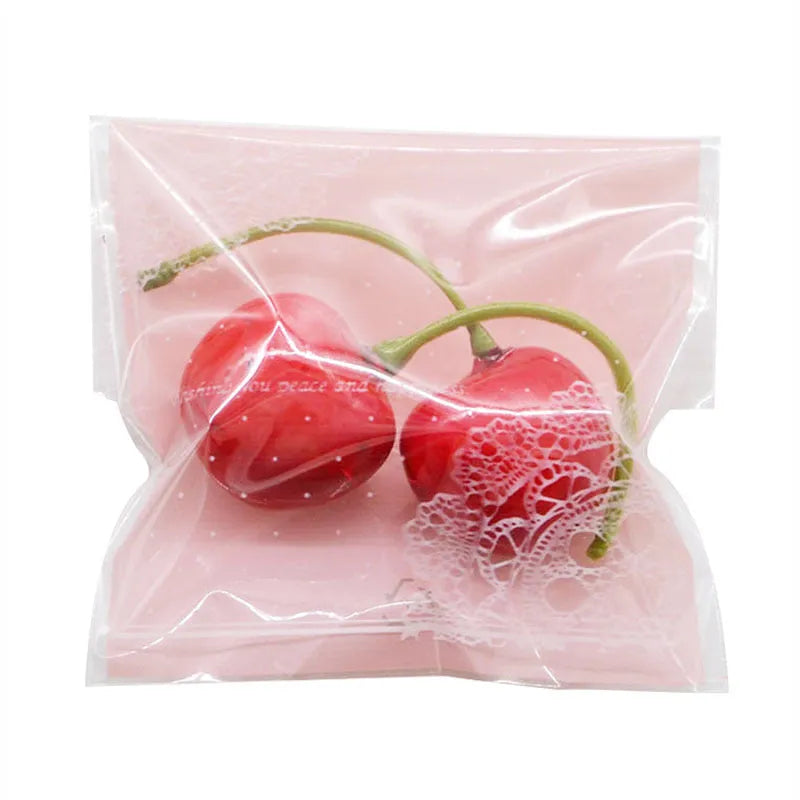 Pink self-adhesive plastic packaging bags in a pack, showing adhesive flap and size scale.