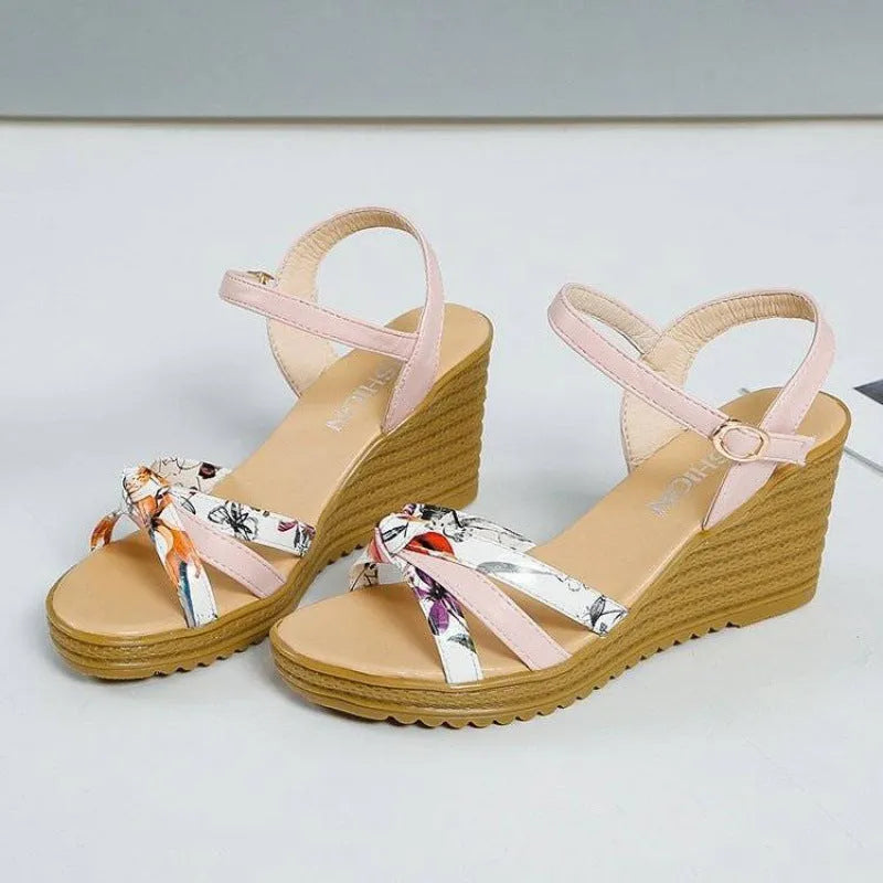 Women's pink wedge sandals with thick heel, fish mouth toe, and buckle closure on a white background