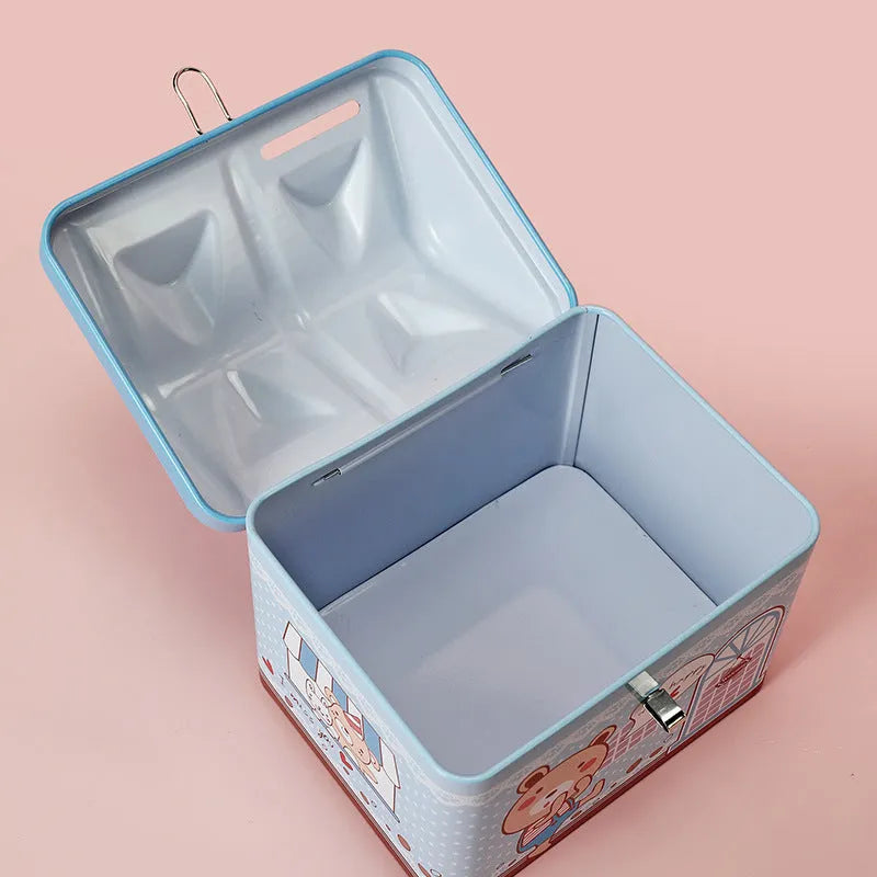Blue or pink round house-shaped tinplate piggy bank with coin slot.