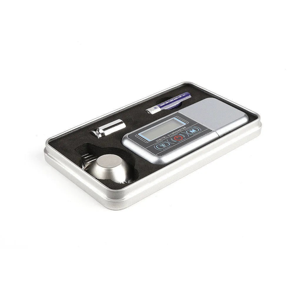A precision electronic scale and turntable needle pressure gauge on a work surface.