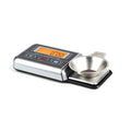 A precision electronic scale and turntable needle pressure gauge on a work surface.
