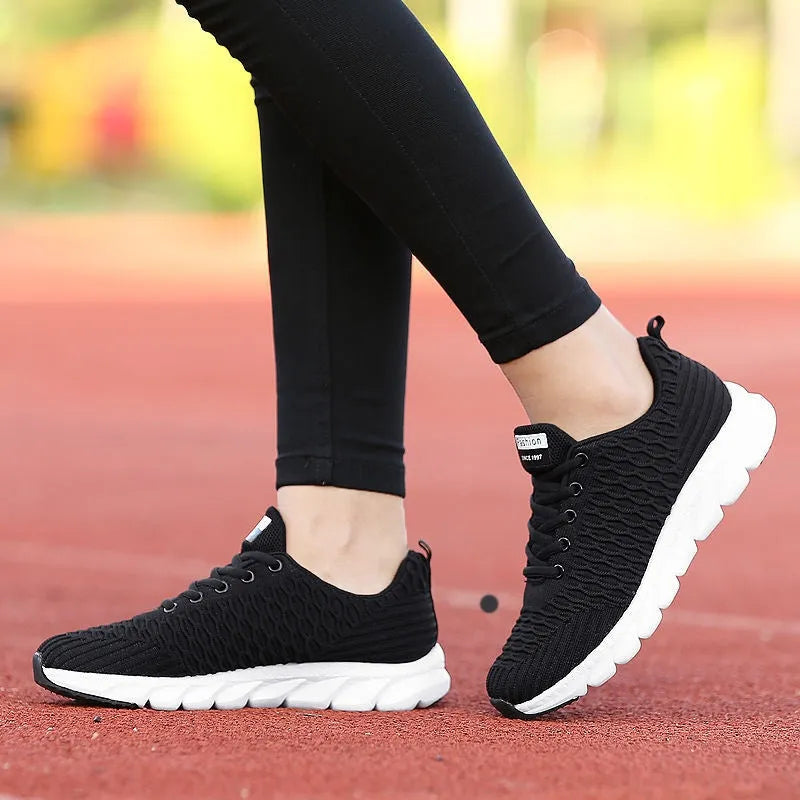 Women's running shoes in black, pink, or white with a fly weaving upper and rubber outsole.