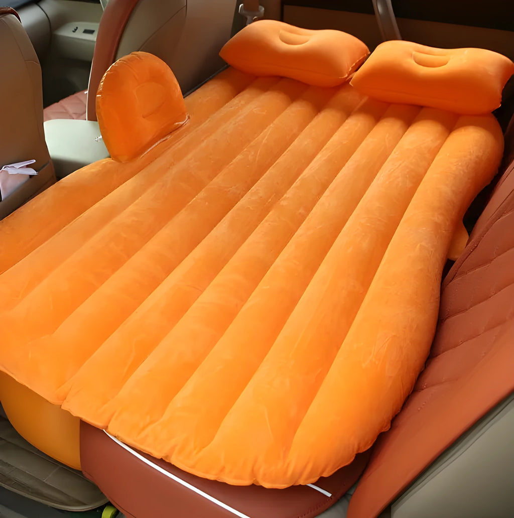Universal inflatable car bed with flocked surface and pillows laid out in a car boot.