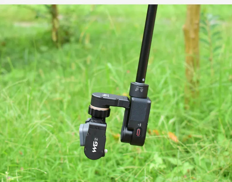 Black retractable aluminium selfie stick extended with smartphone attached and remote shutter in hand.