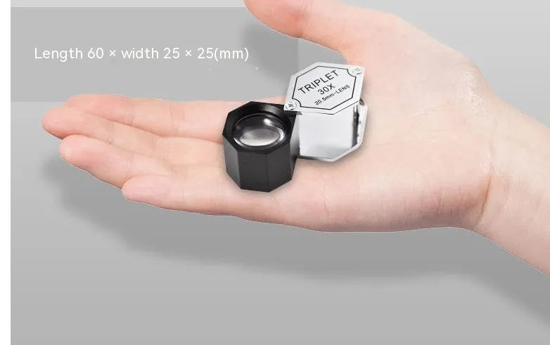 Handheld metal portable magnifying glass for jewellery and coin inspection with optical glass lenses.