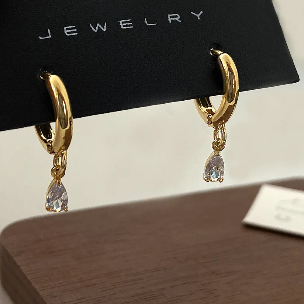 Women's zircon jewellery set showing geometric pendant necklace, matching earrings and coordinating anklet