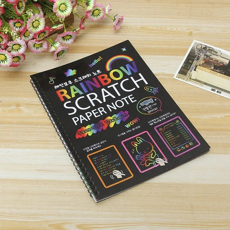 Large sheet of black scratch art paper for children, with a colourful revealed pattern showing through scraped areas.
