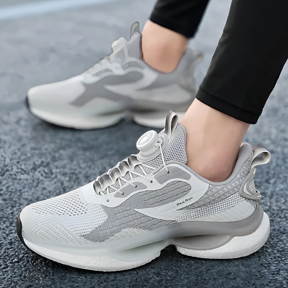 Men's low-top running shoes in beige with a rotating buckle and mesh upper, shown on a white background.